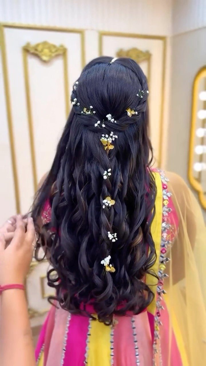 Long dark half-up waves decorated with cascading white and yellow flowers