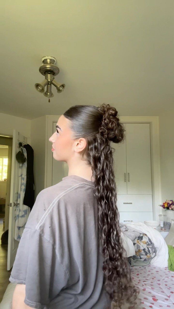 Woman showing a half-up bun with long, loose wavy hair