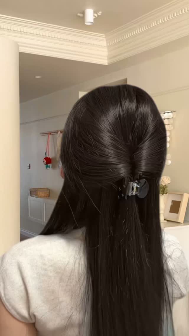 Long dark hair styled half up with a clip and left loose below