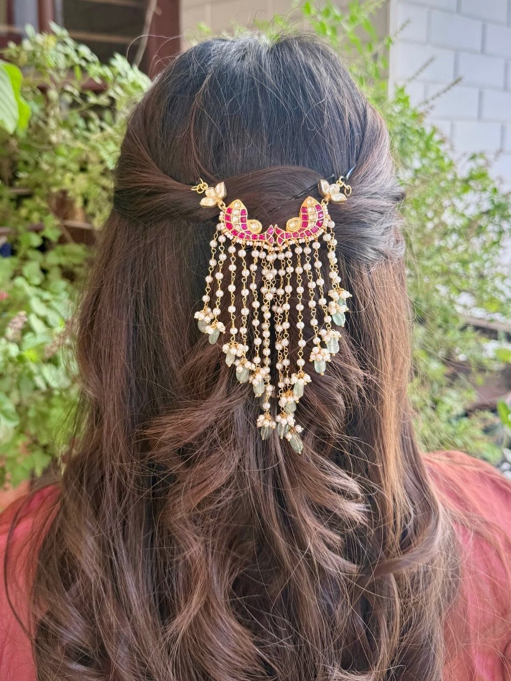 Long dark hair in a twisted half-up style with dangling pearl strands