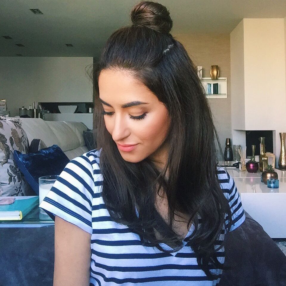 Woman wearing a relaxed half-up top knot with long dark hair down