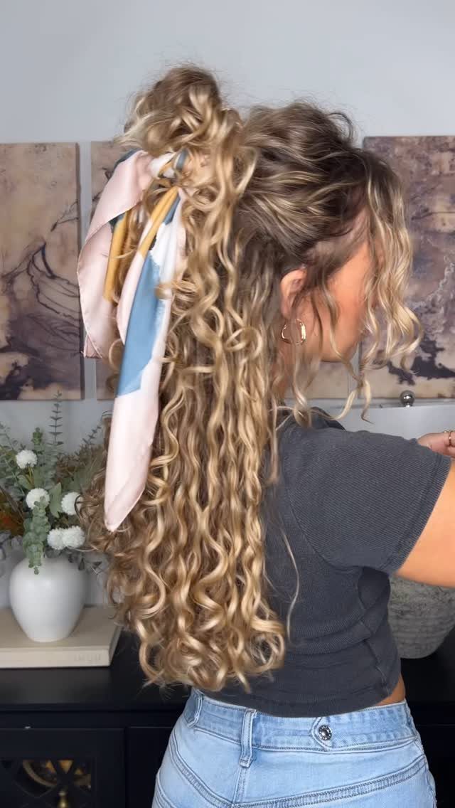 Curly blonde half-up hairstyle secured with a pastel striped scarf