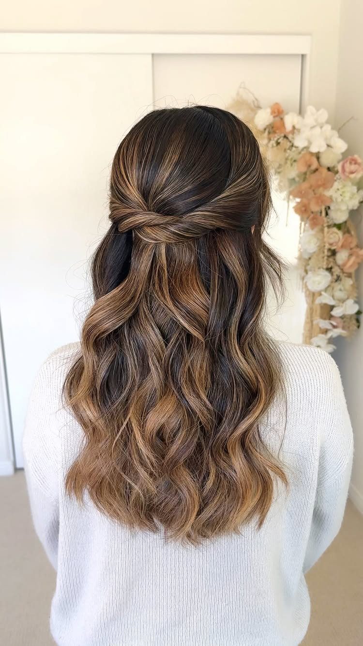 Twisted half-up brown waves secured at the back above loose hair