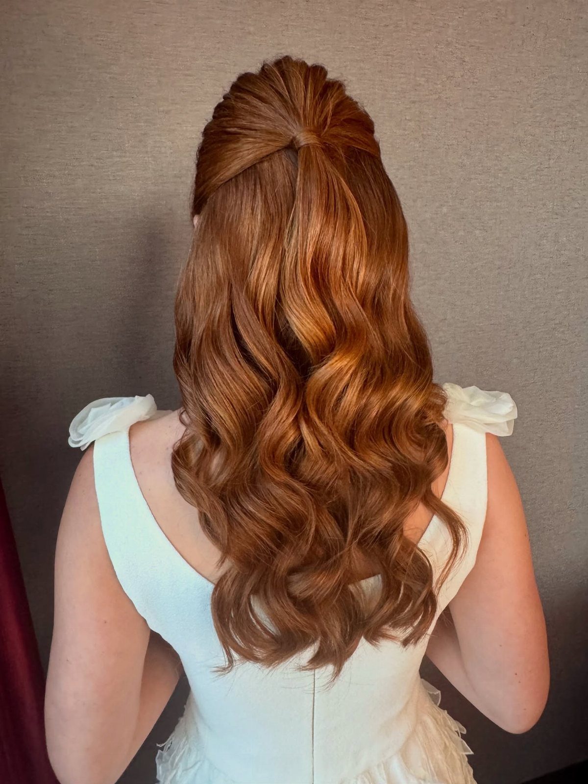 Auburn half-up hairstyle with voluminous crown and long glossy curls