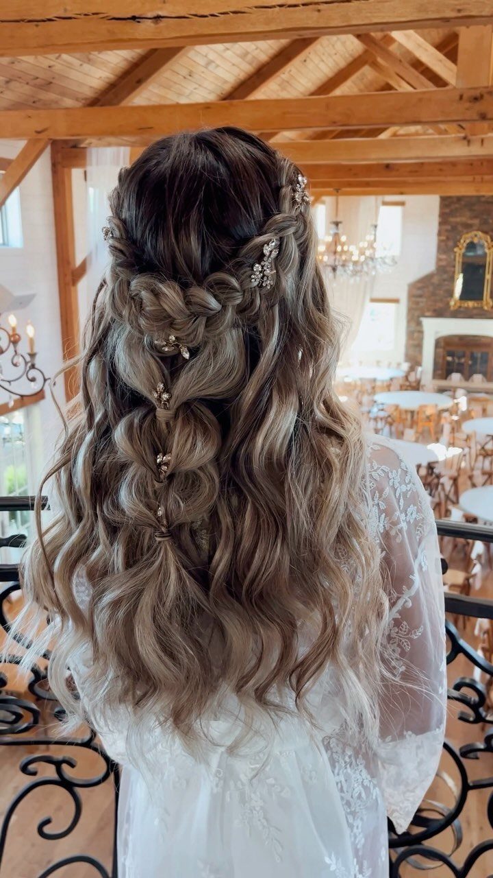Bride with loose lace braid half-up hairstyle and long flowing waves