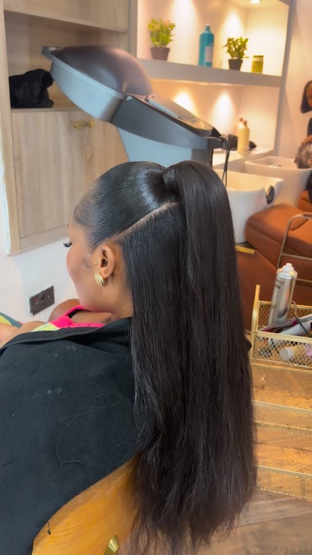 Long dark hair styled in a high half-up ponytail at a salon