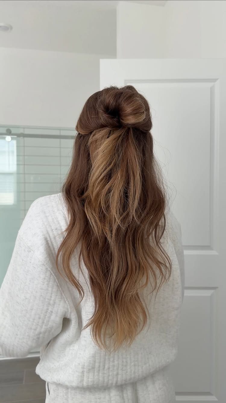 Long wavy brown hair gathered into one loose bun at the crown