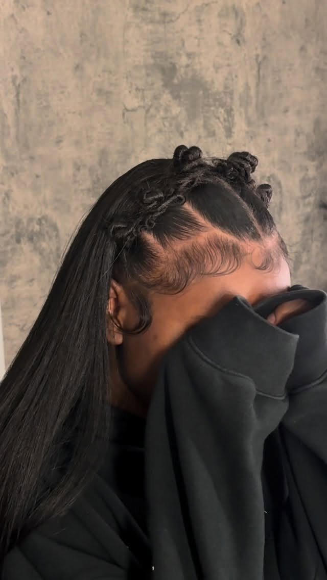 Long black hair styled half-up with small knots along the crown