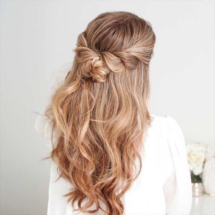 Blonde wavy hair gathered in a loose half-up twist with flowing lengths