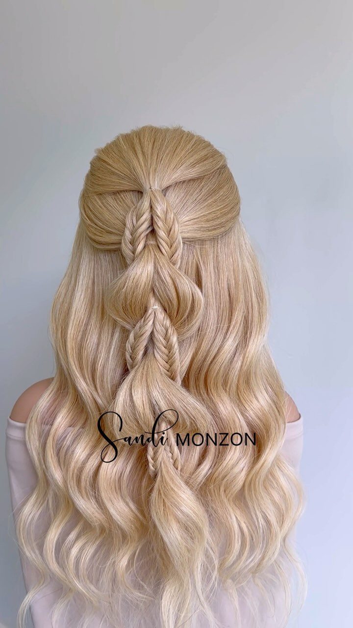Blonde half-up braid secures a teased crown above long, loose waves.