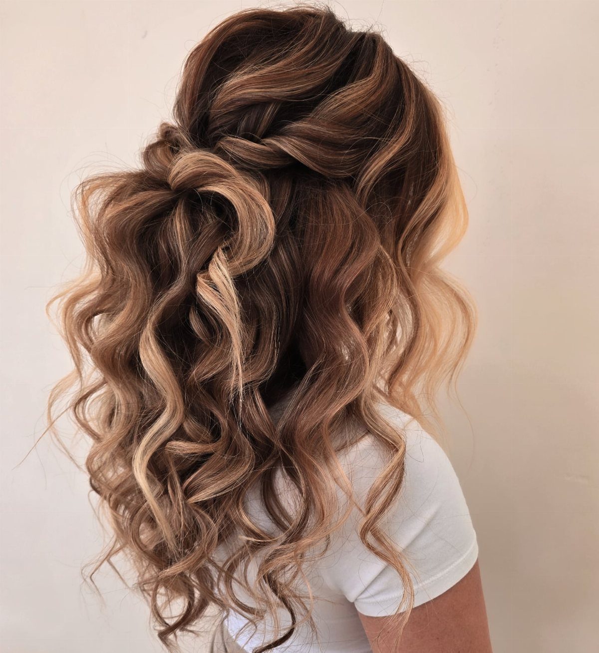 Twisted half-up bun paired with long, loose ringlet curls