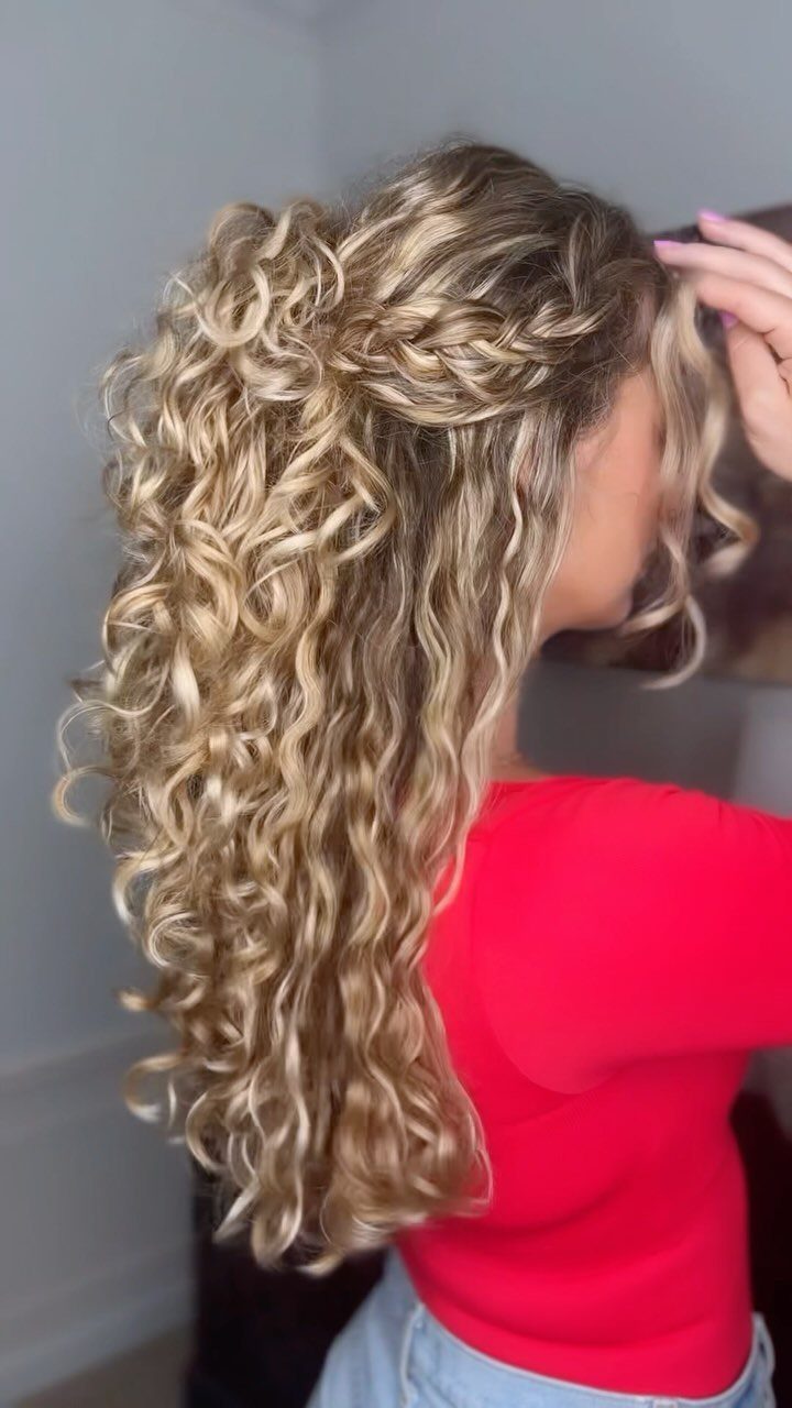 Long blonde curls with a thick side braid swept across the crown