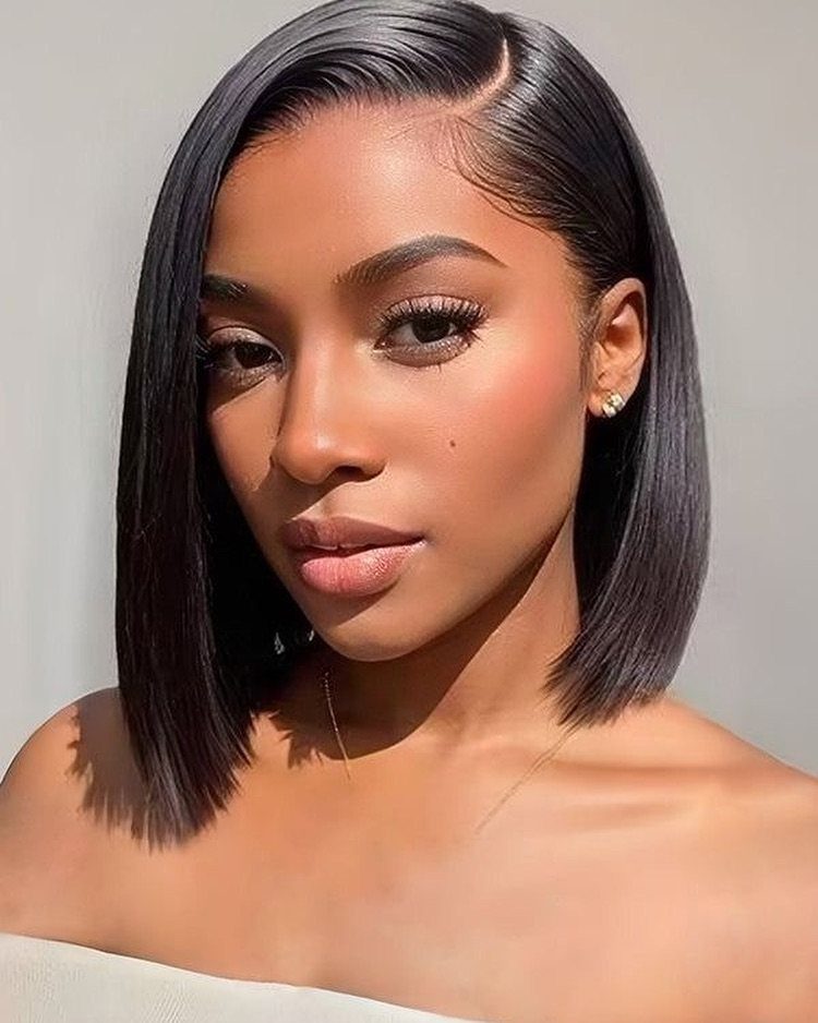 Woman models a sleek black bob with a deep side part