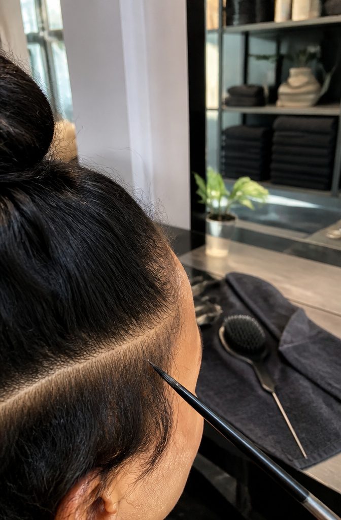 Pointed edge brush beside separated baby hairs along a hairline