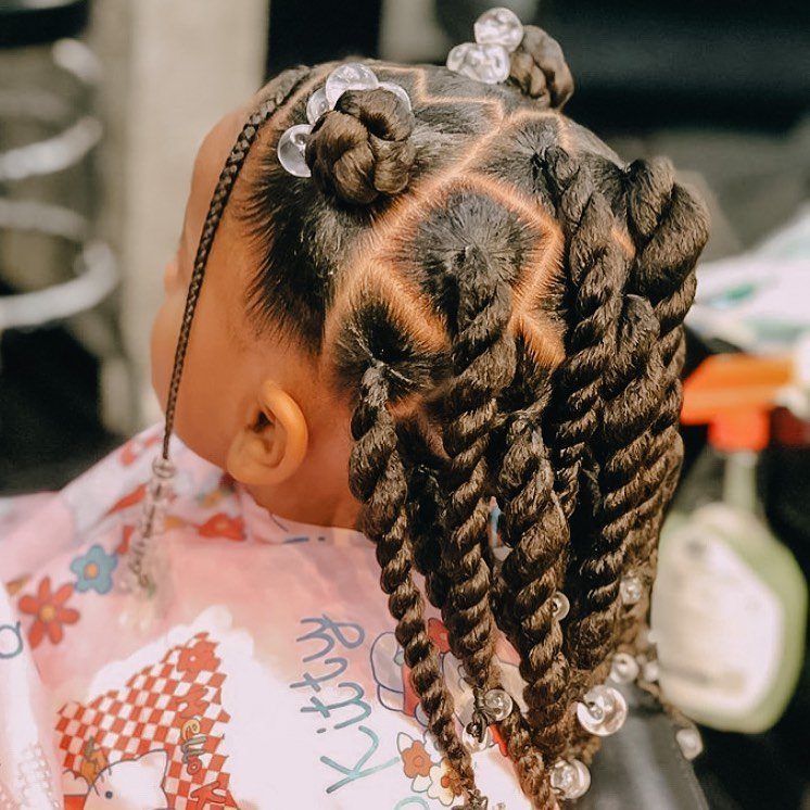 Child with braided twists, small buns, and clear beads in styled hair