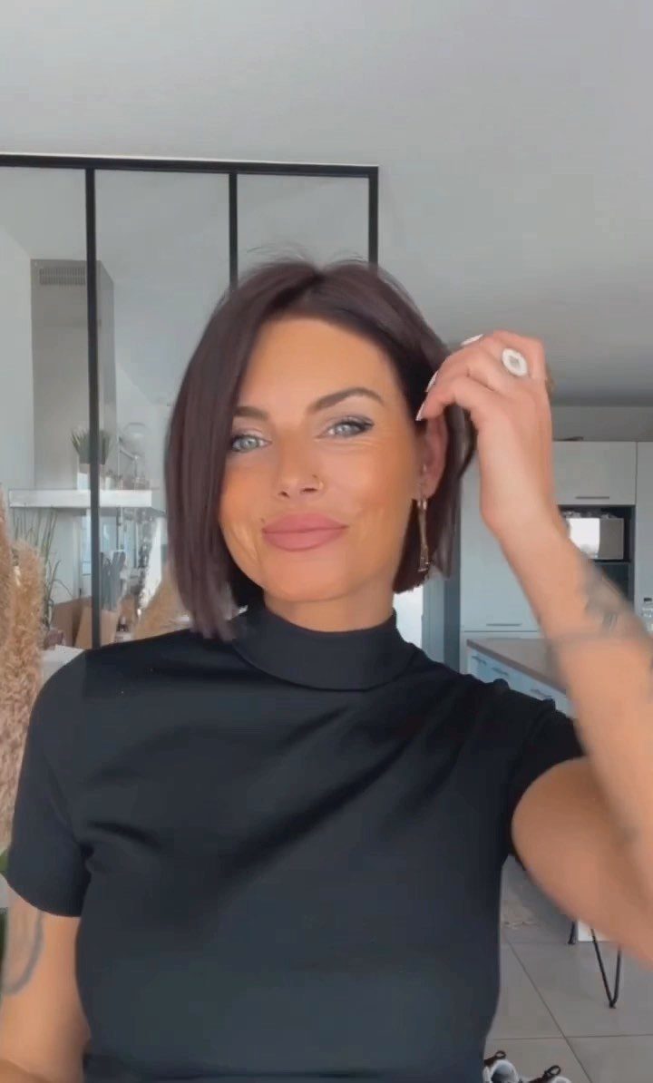 Woman showing a smooth, dark brown chin-length bob haircut