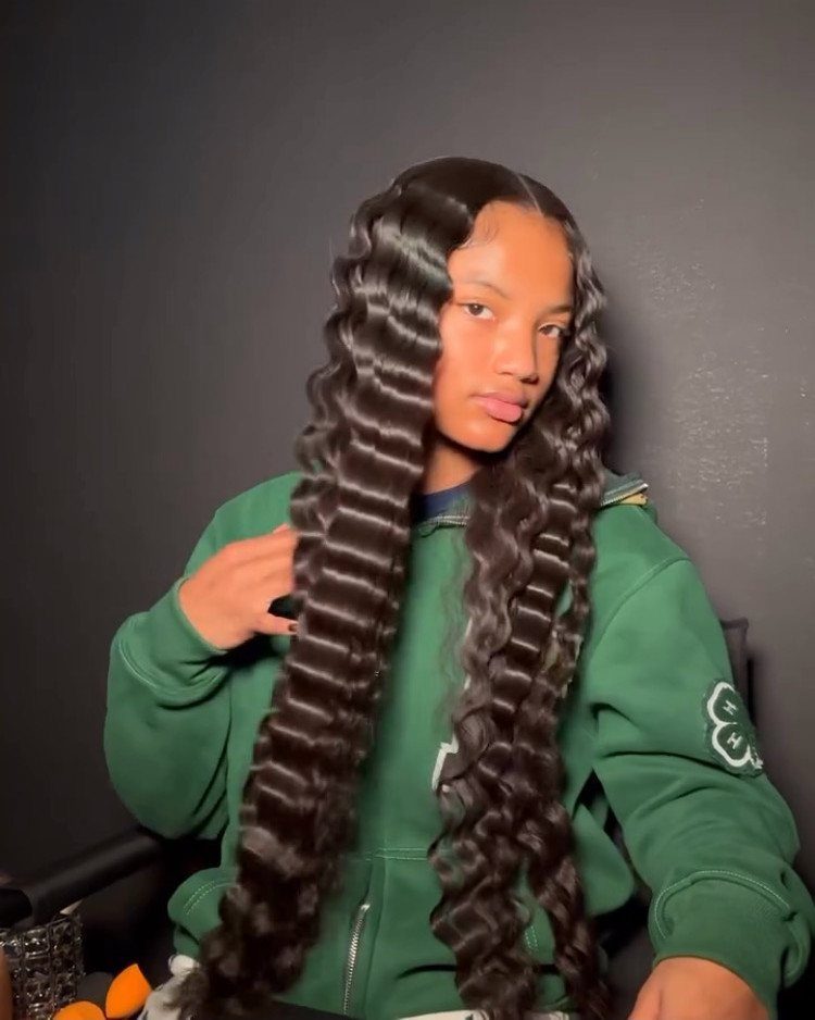 Long dark hair styled in large, glossy, softly defined crimped waves