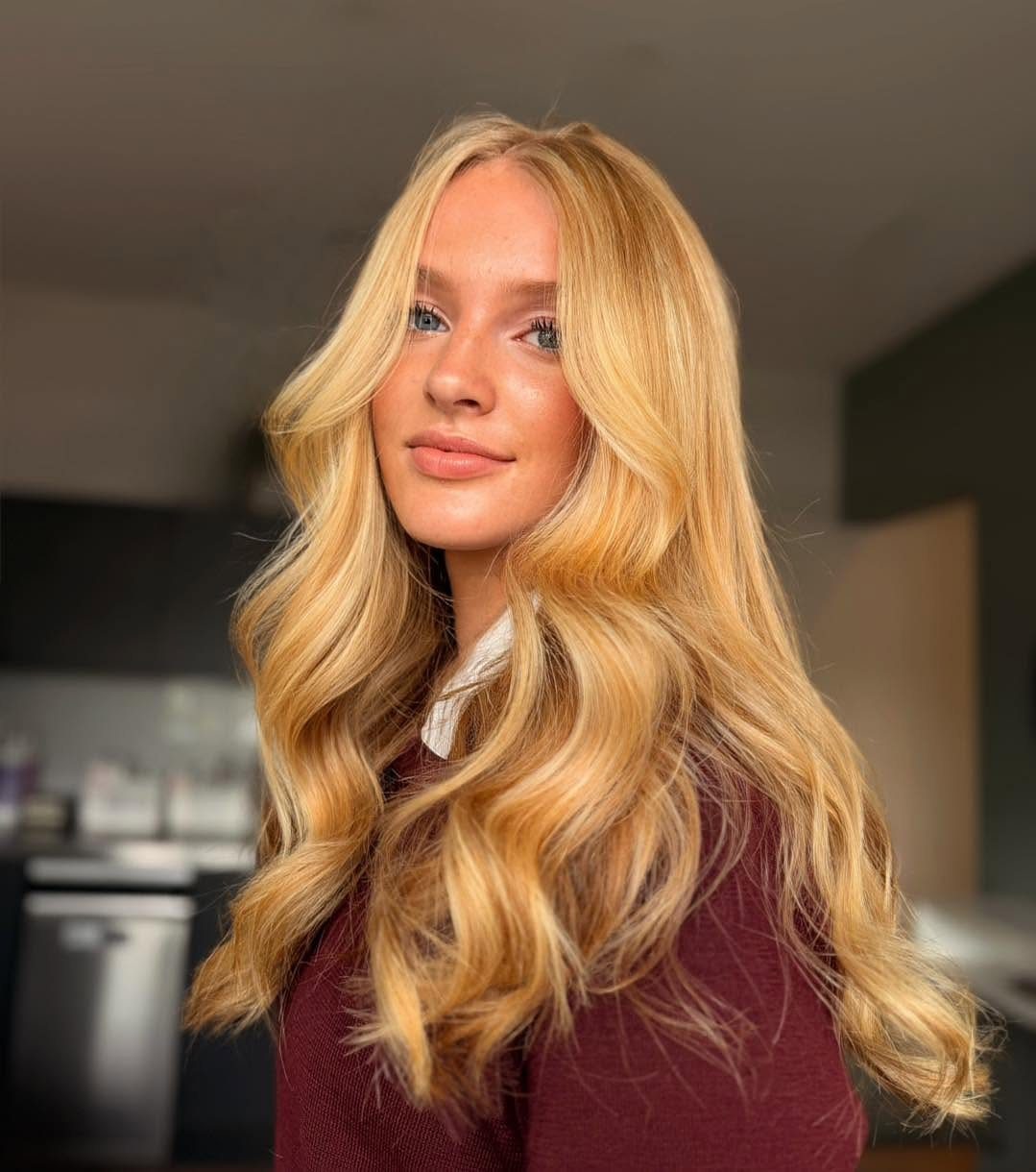 Woman with long, warm golden-blonde hair styled in loose waves