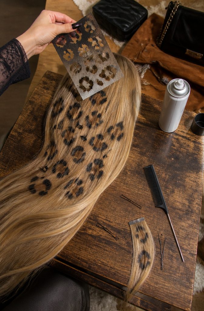 Leopard print stencil and colored hairspray beside long hair