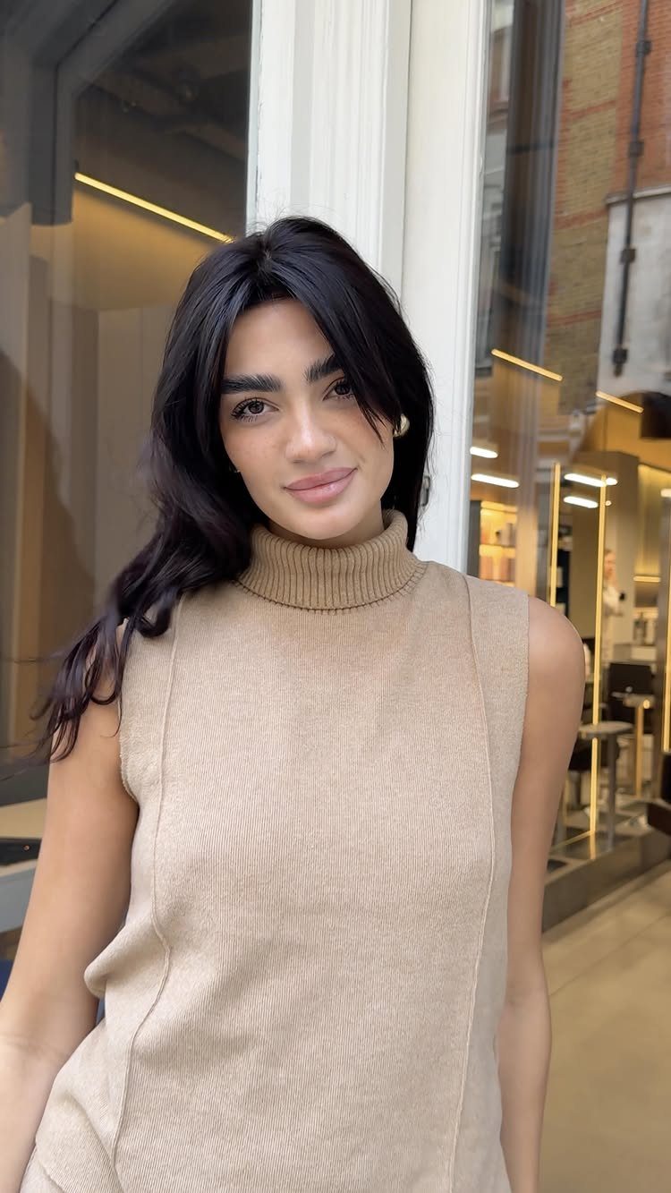 Woman with long glossy espresso brunette hair and loose face-framing waves