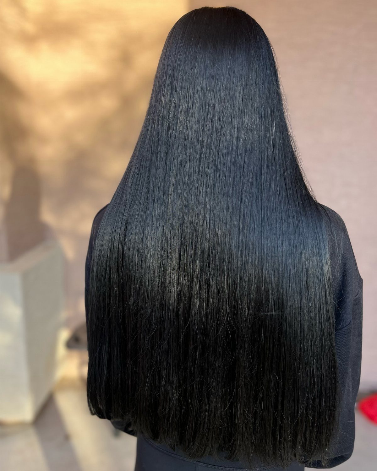 Long glossy black hair falls straight down the back