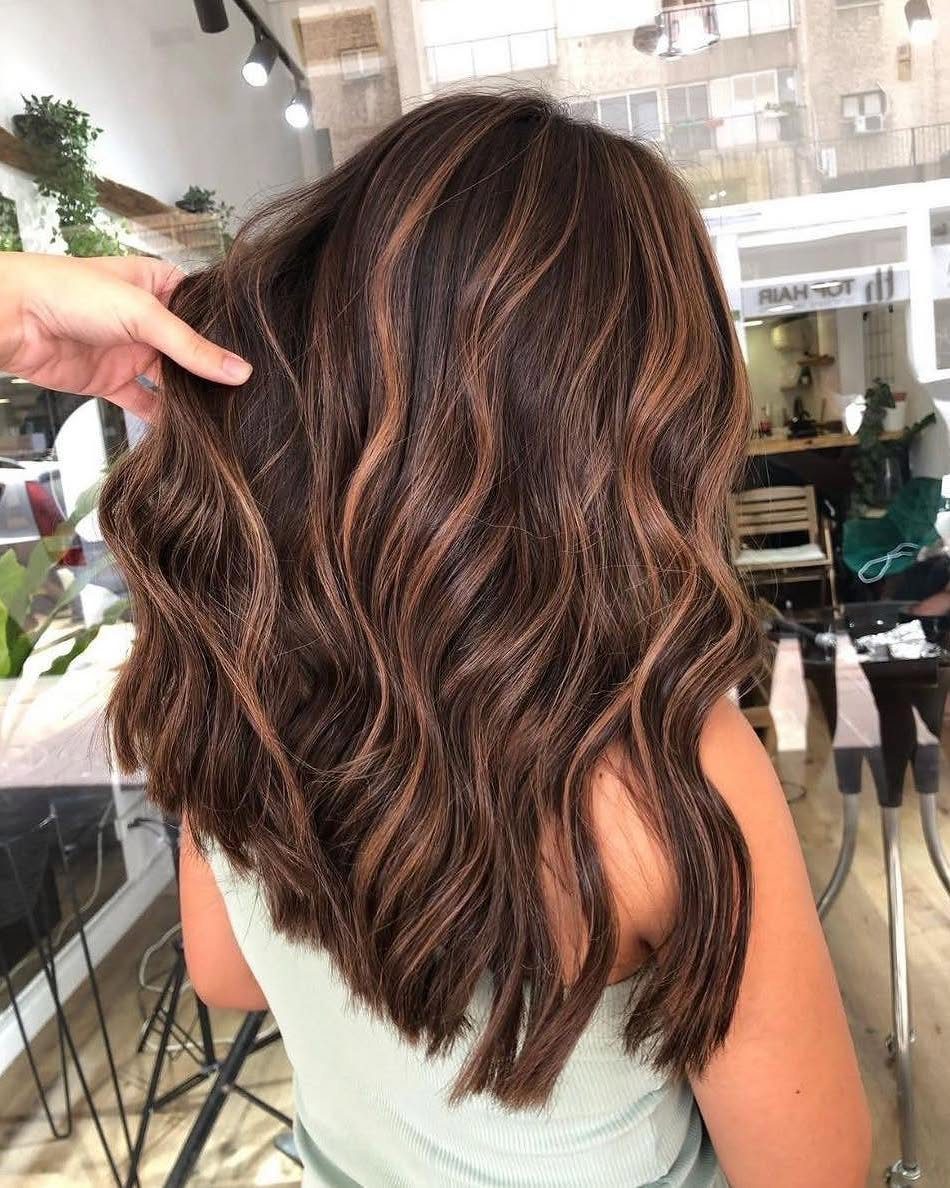 Long wavy dark brown hair with subtle caramel highlights shown from behind