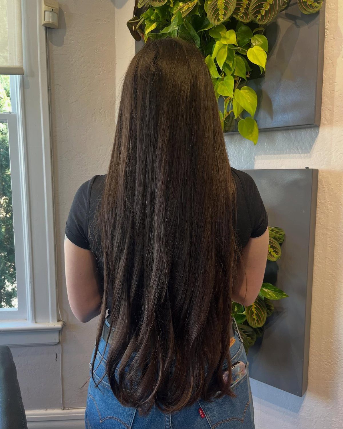 Long dark brown hair falls in a full, slightly wavy shape past the waist