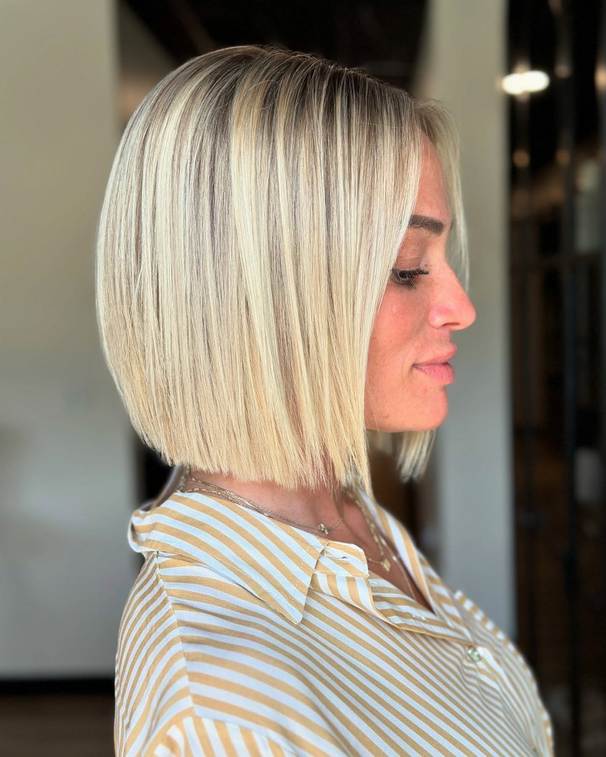 Woman with a sleek blonde blunt bob ending in a straight chin-length edge
