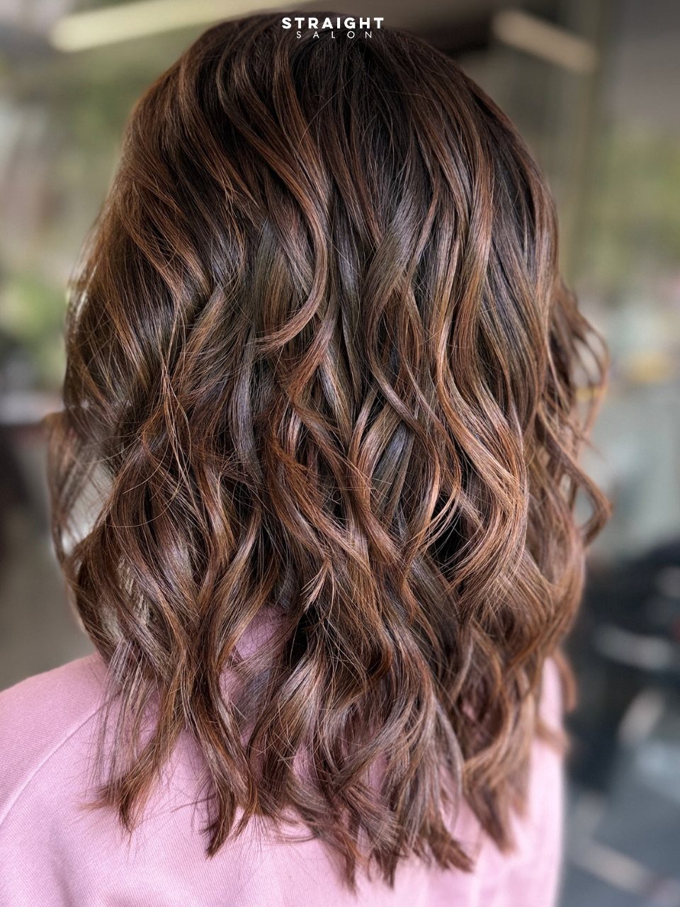 Shoulder-length brown hair styled in loose, defined waves