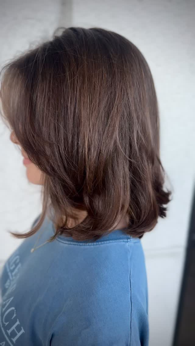 Dark brown textured long bob with softly curled ends, shown from the side