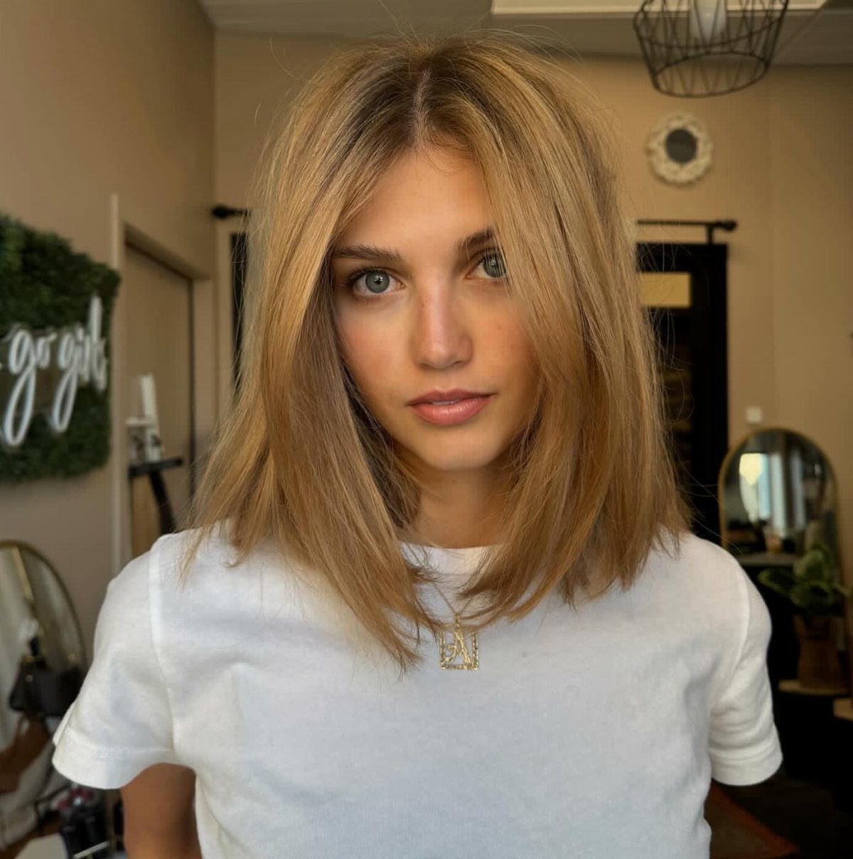 Woman with straight, center-parted blonde hair cut to shoulder length