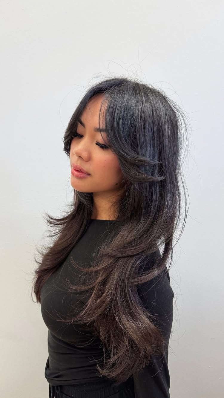 Woman displaying long dark hair with face-framing layers