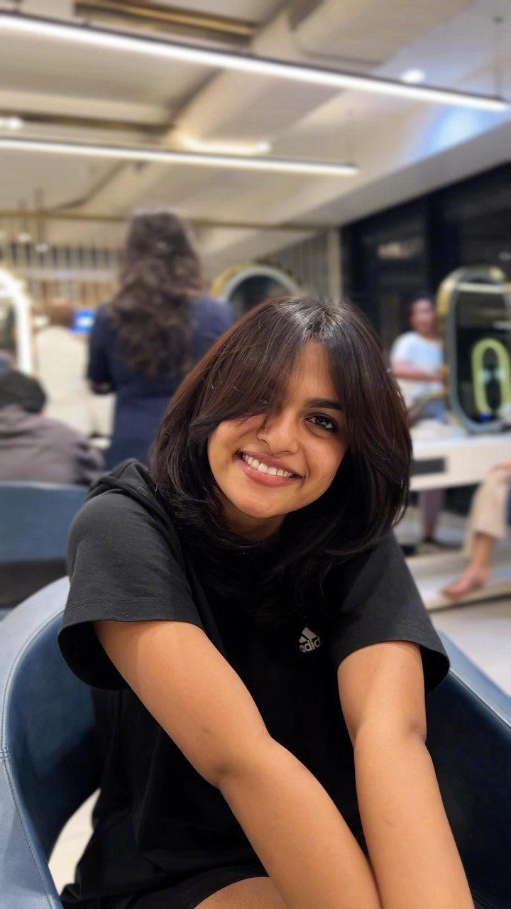 Person with a dark medium-length lob and long center-parted bangs