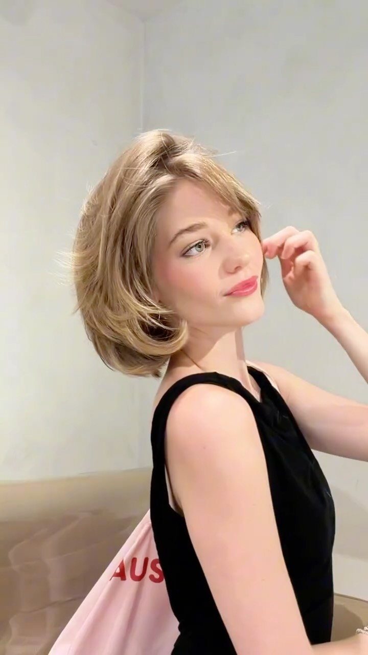 Woman with a layered chin-length blonde bob and curled ends