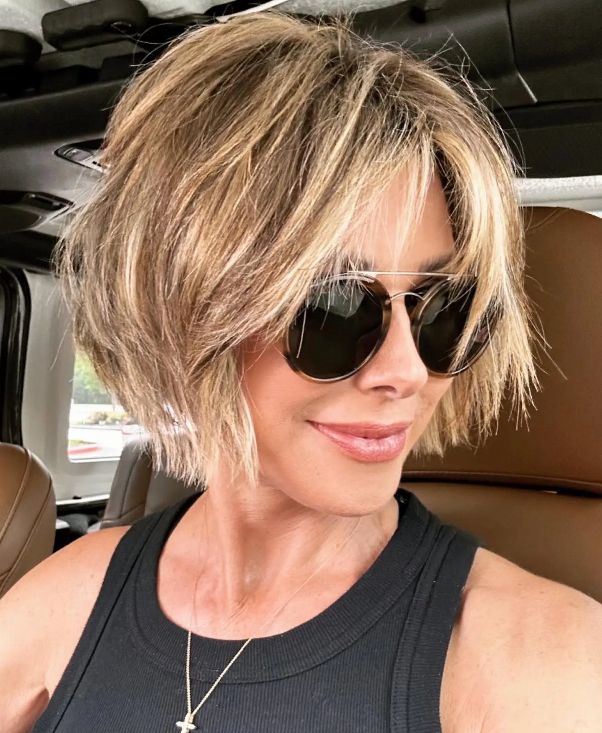 Woman wearing a chin-length blonde bob with face-framing layers and wispy bangs