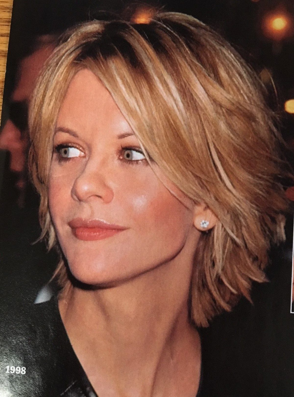 Woman with layered blonde hair styled in outward-flipped ends