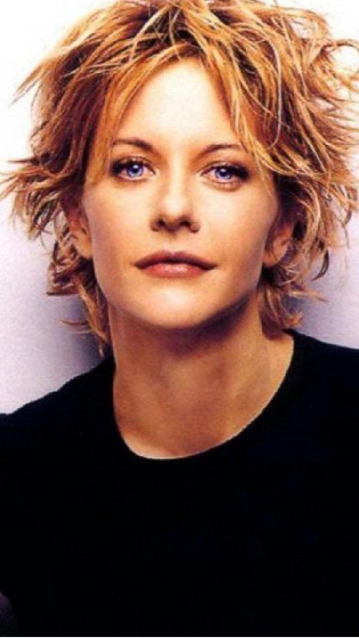 Woman with tousled, layered auburn hair and a black top