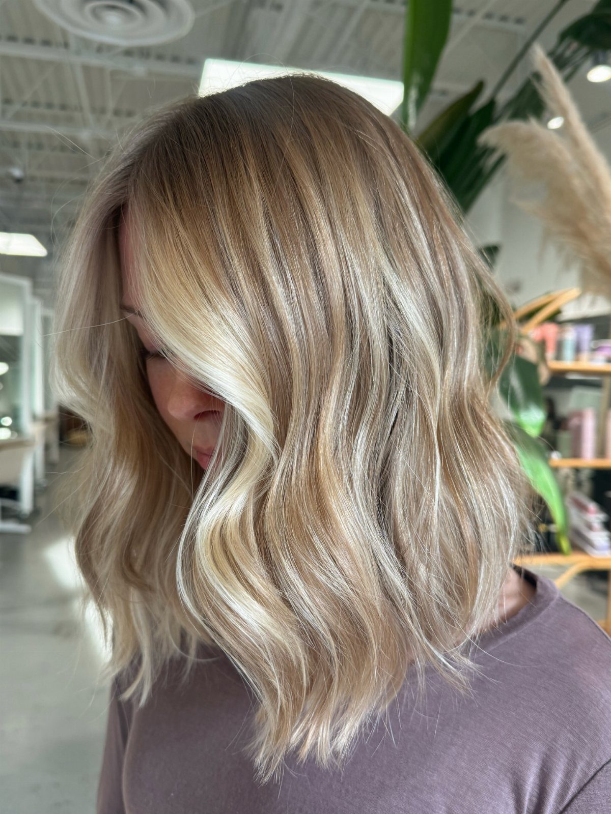 Shoulder-length blonde hair falls in loose waves with long face-framing layers