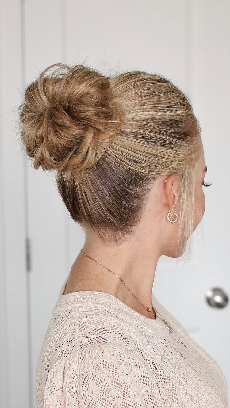 Blonde hair styled in a loose high messy bun, viewed from behind