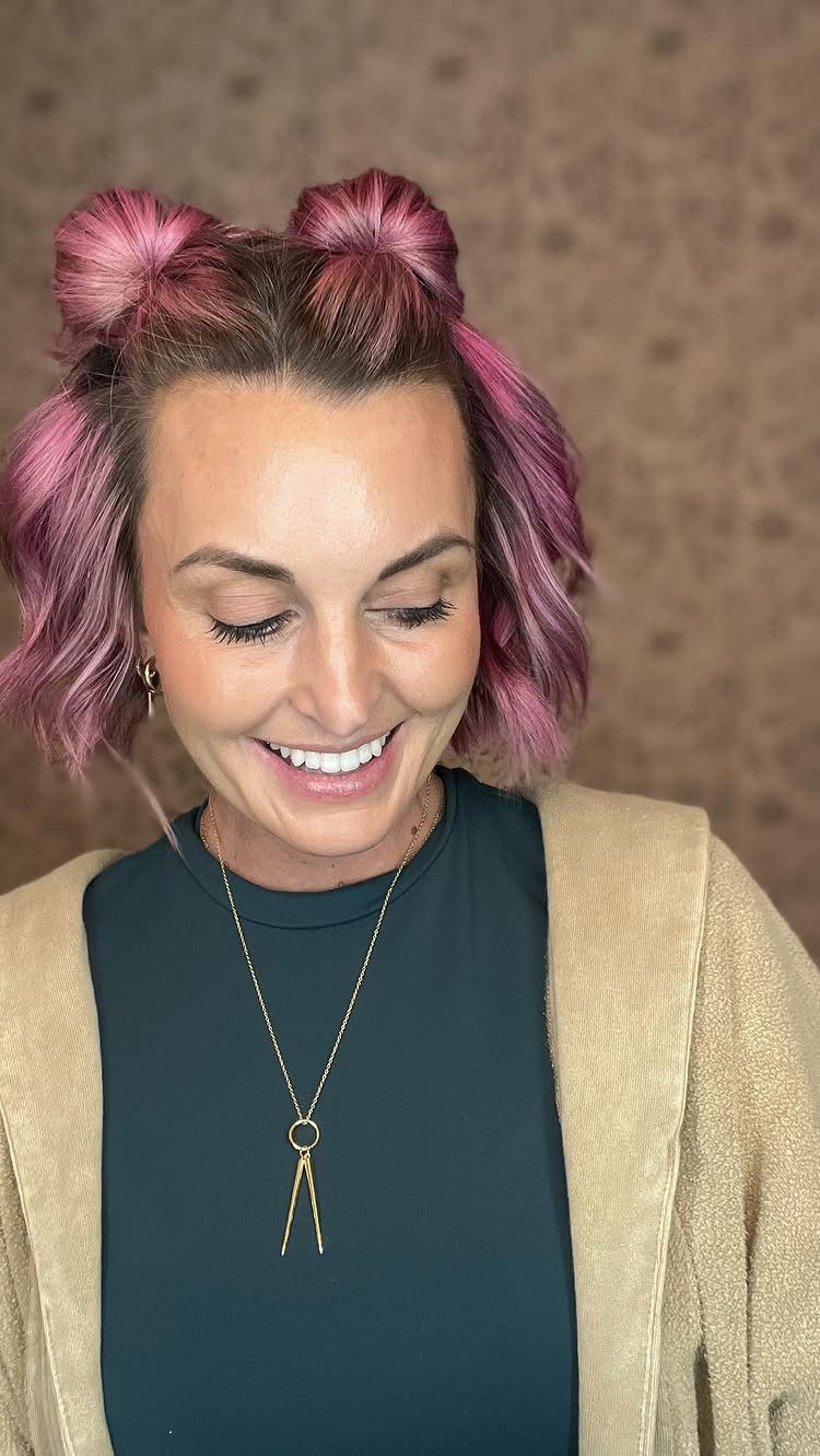 Woman with pink hair wearing two messy space buns on top