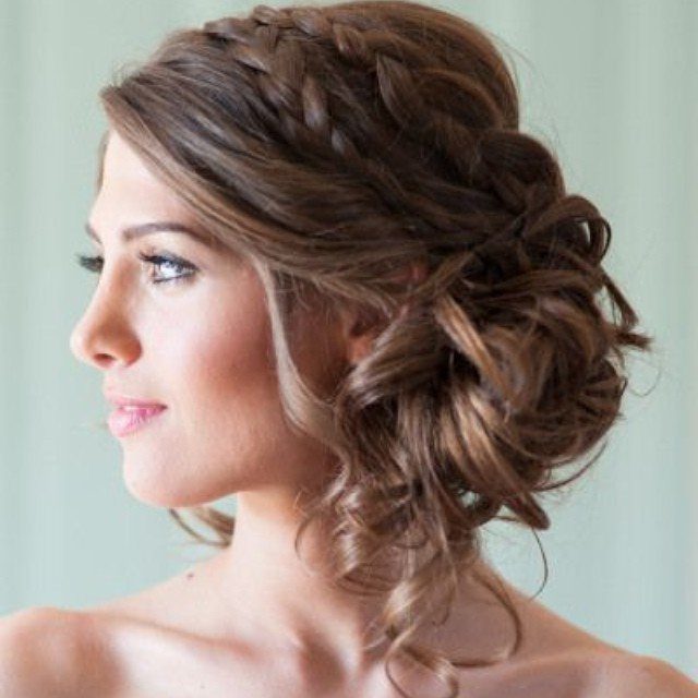 Woman wearing a loose side bun with a braid across the crown