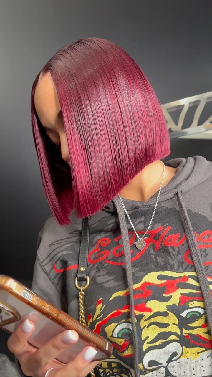 Magenta blunt bob with a center part falls evenly to the chin