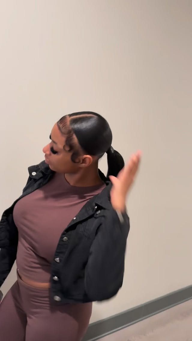 Woman with sleek center-parted hair tied in a low ponytail