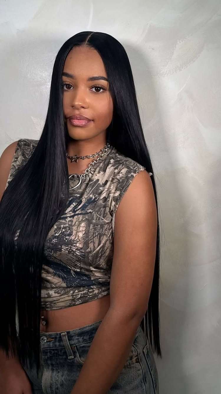 Woman with long, sleek black hair and a precise middle part