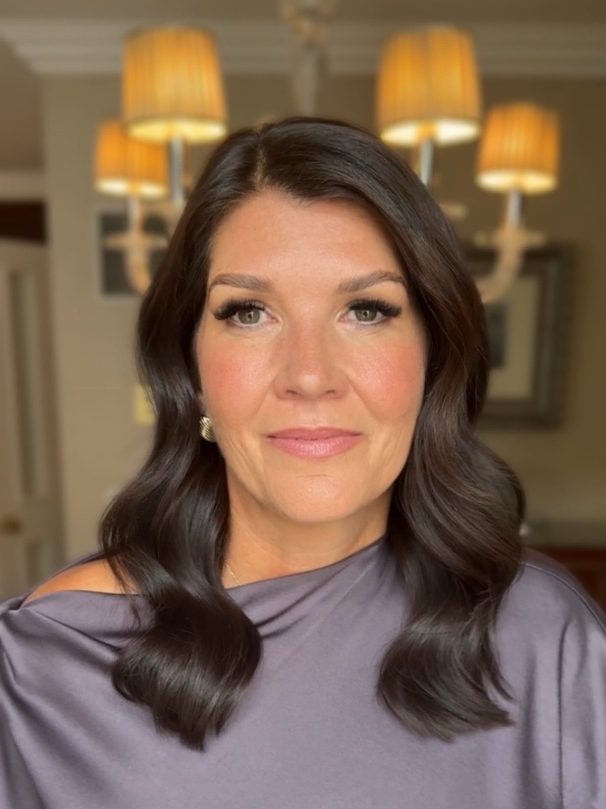 Woman with a polished, voluminous blowout in long dark waves