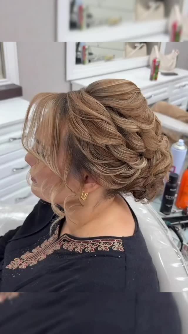 Woman displaying a curled low chignon with loose face-framing strands