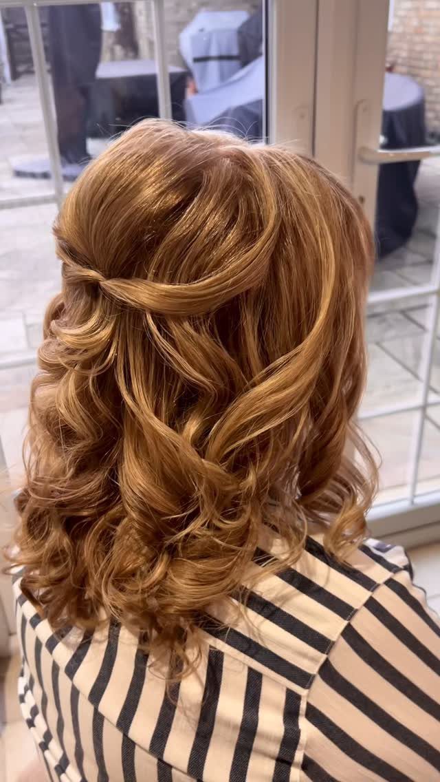 Long auburn curls pinned half-up across the back of the head