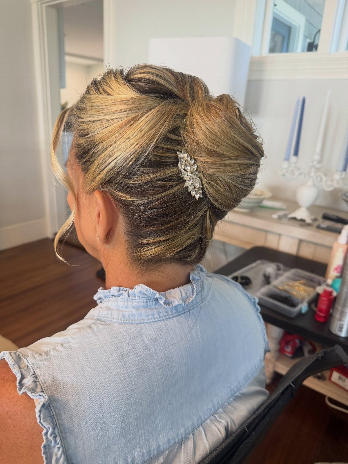 Blonde updo with jeweled clip and loose curls viewed from behind