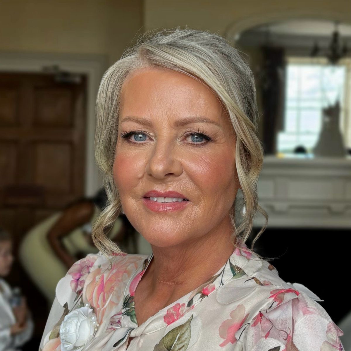 Older woman with silver-blonde hair in loose face-framing waves