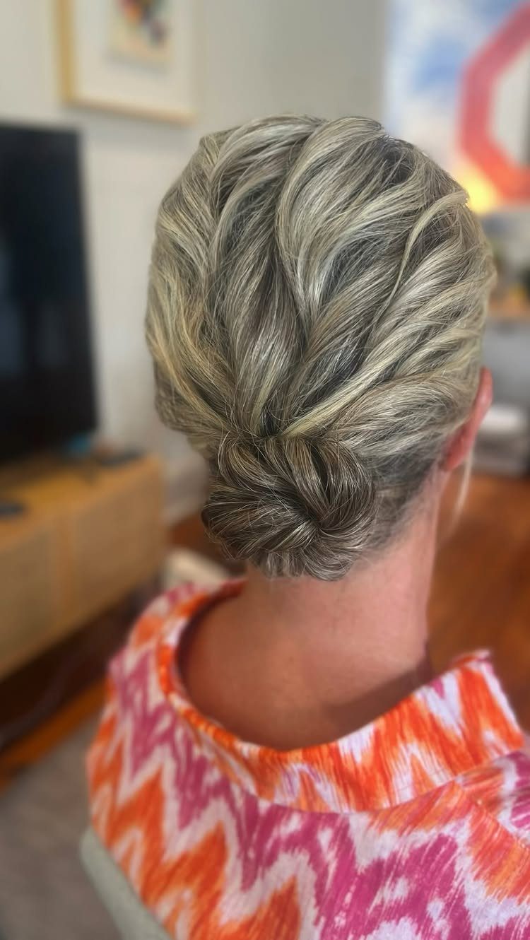 Silver-blonde hair pinned into a softly textured low updo on a woman